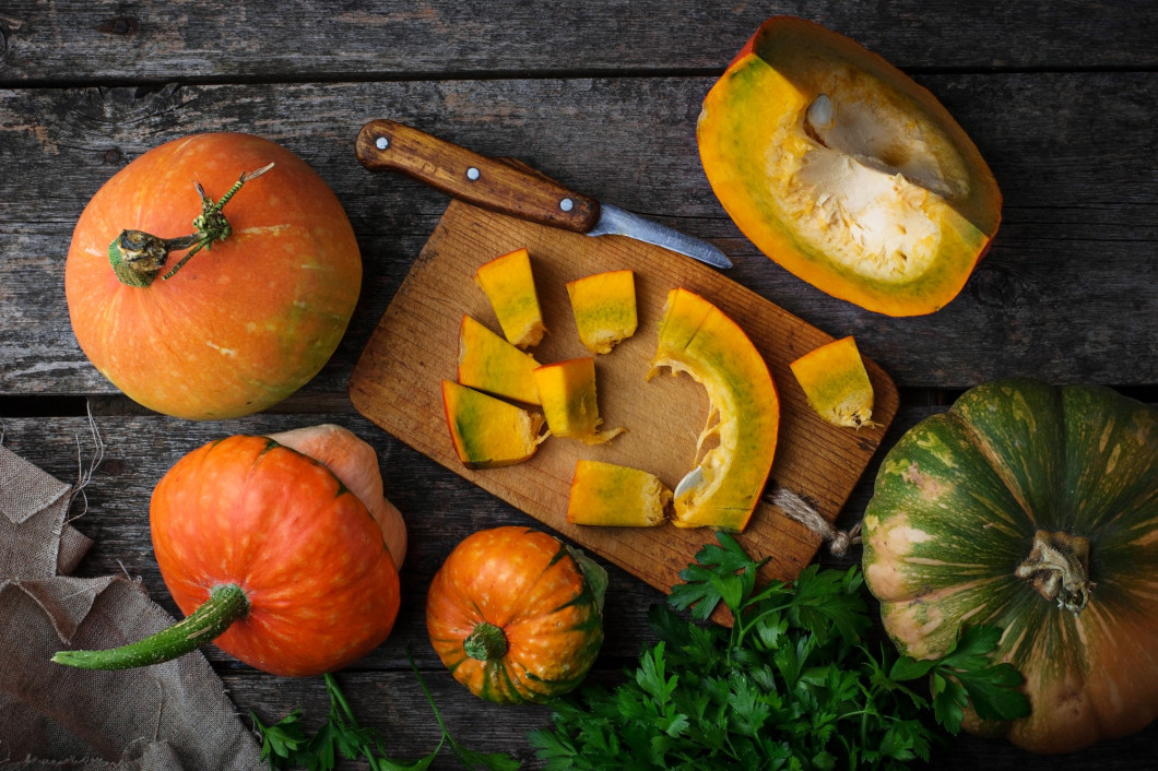 Raw chopped pumpkin on wooden background