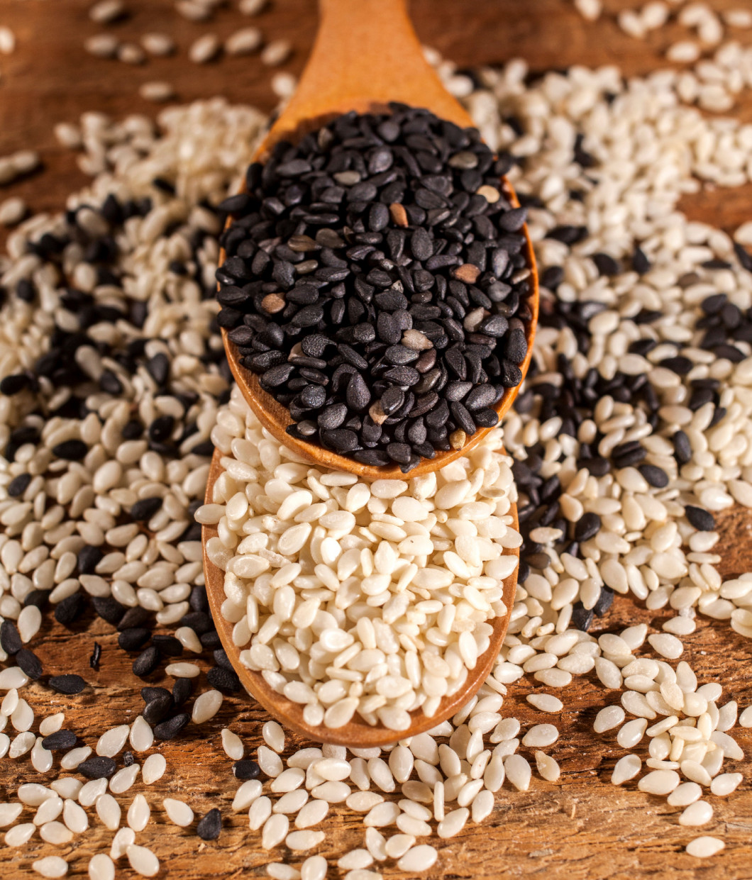 Fresh black and white sesame seeds in spoons