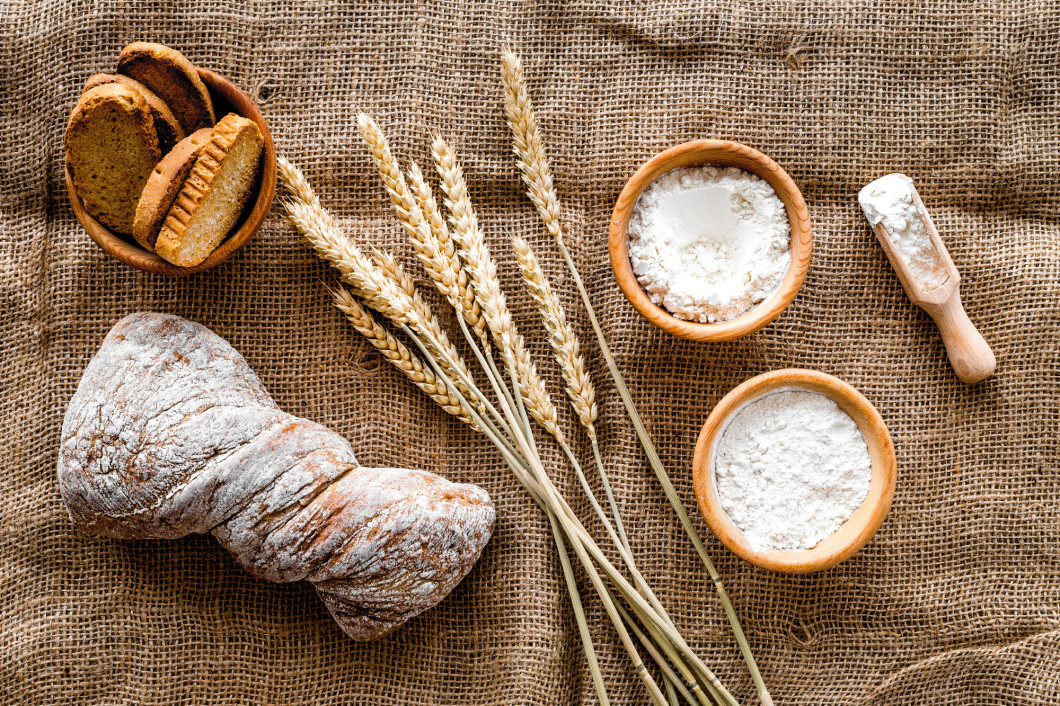 baking fresh wheaten bread on bakery work table background top view