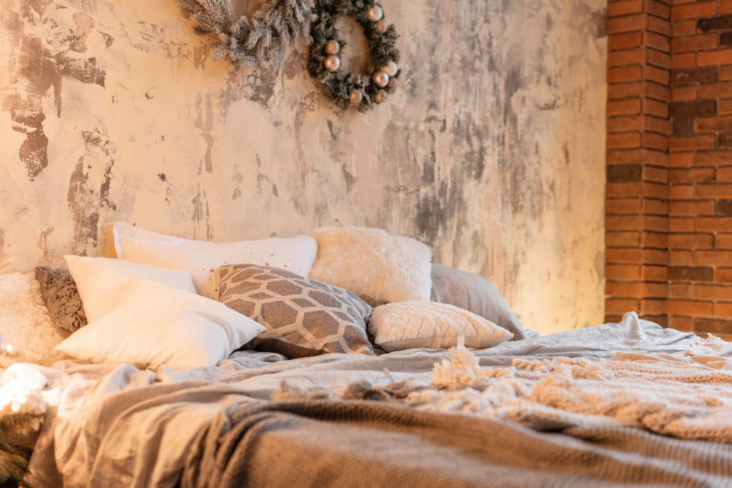 Loft apartments, brick wall and Christmas tree. Bed in the bedroom, high large Windows