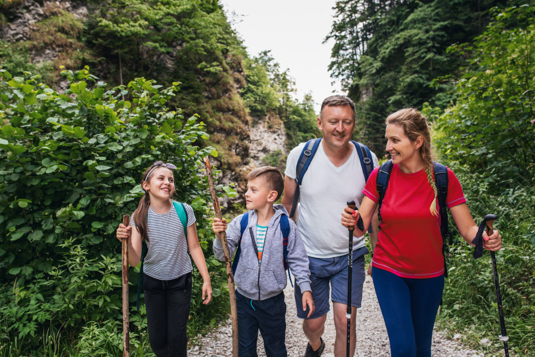 Smiling family of four hiking on a trail together