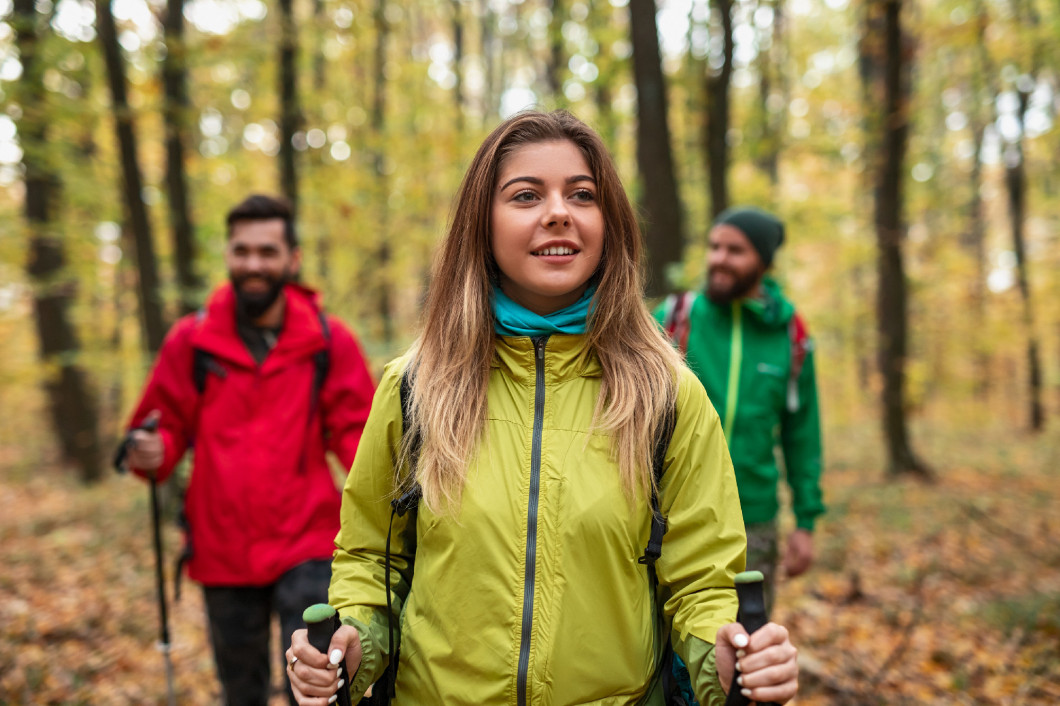 Active young friends hiking in autumn forest