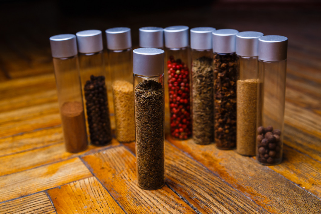 Assorted spices in bottles on wooden background