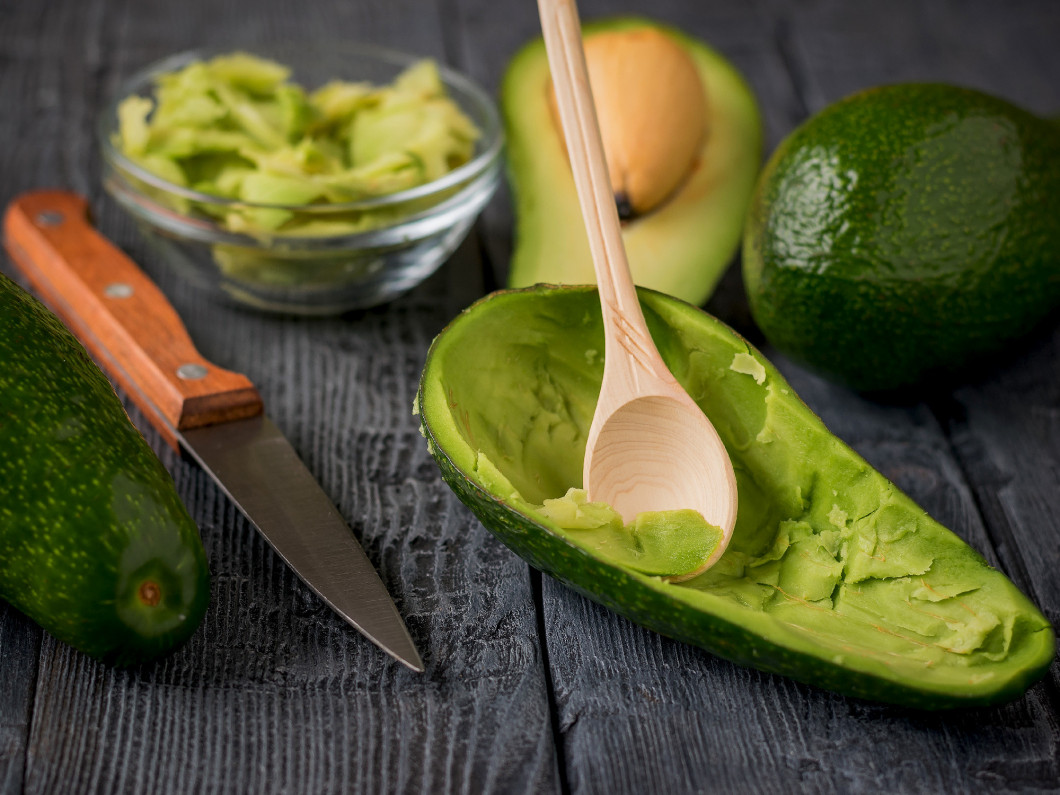 Half avocado pulp with the remote on the table.