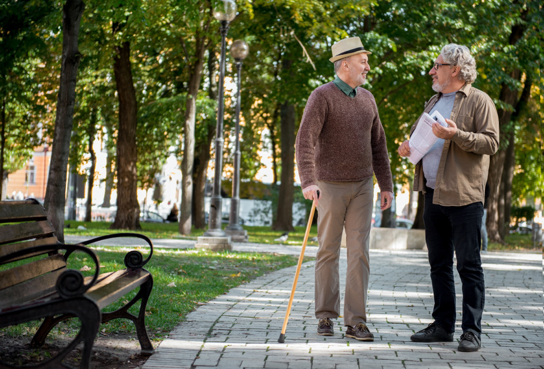 Cheerful mature friends talking in park