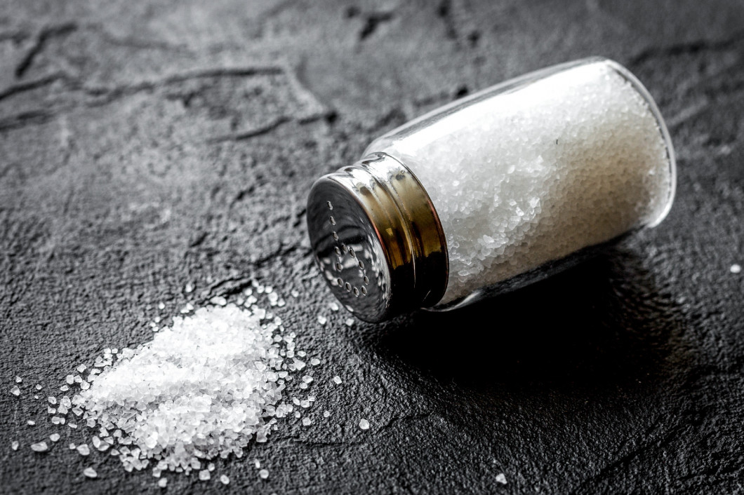 Cooking set with salt in glass bottle on dark background