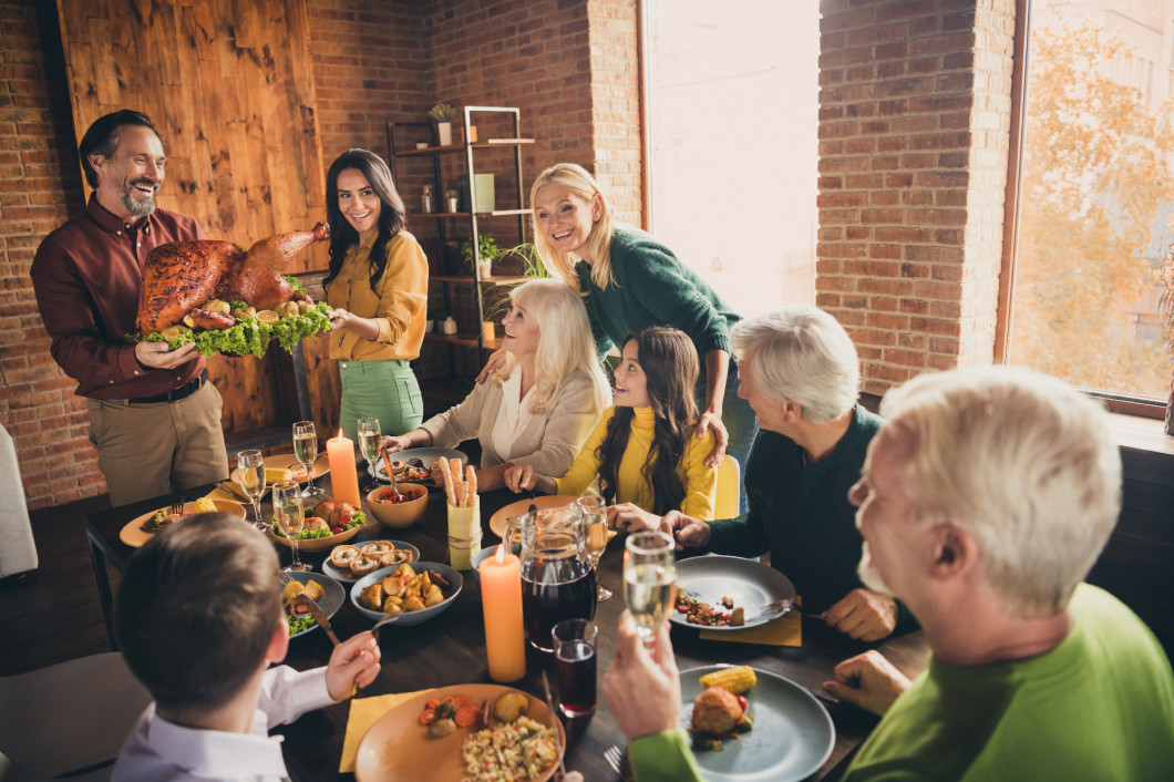 Portrait of nice attractive cheerful affectionate family gathering housekeeper carrying plate fresh homemade turkey serving table spending time at modern loft industrial brick interior house
