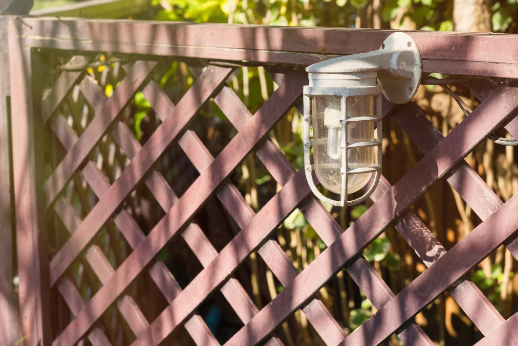 Lamps for illumination on a wooden fence in the garden.