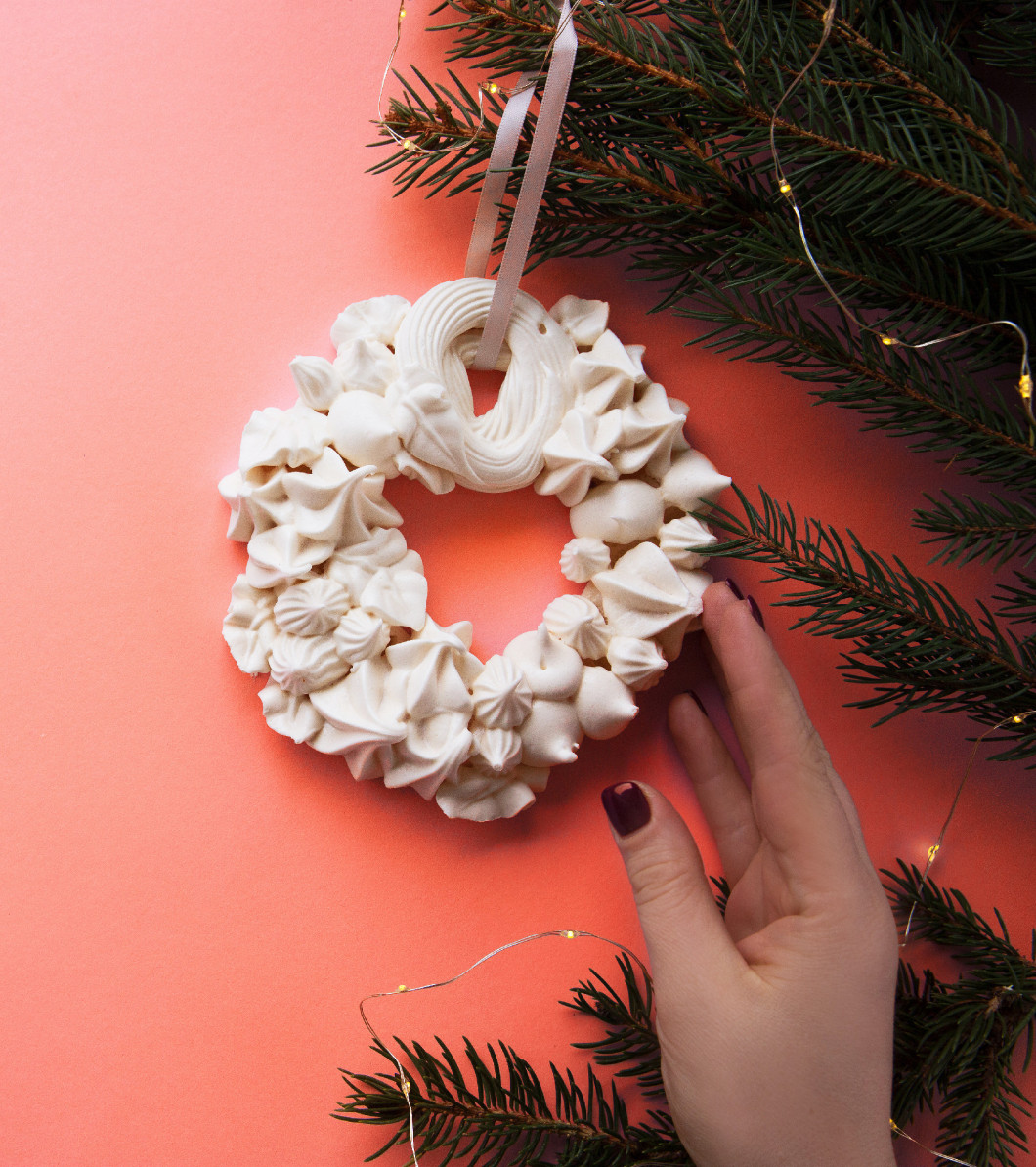 Christmas meringue wreath on the fir branch on the living coral 