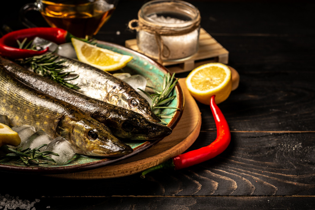 Healthy food clean eating selection: fish pike, vegetable, superfood on black concrete background. Flat lay. Free copy space