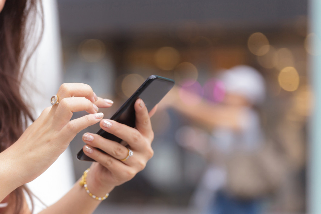 Close up of woman hands holding smart phone with blurred backgro