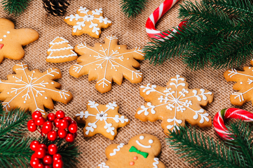 Christmas gingerbread cookies homemade with branches of Christmas tree and New Year decor on table with burlap tablecloth. Merry Christmas postcard.