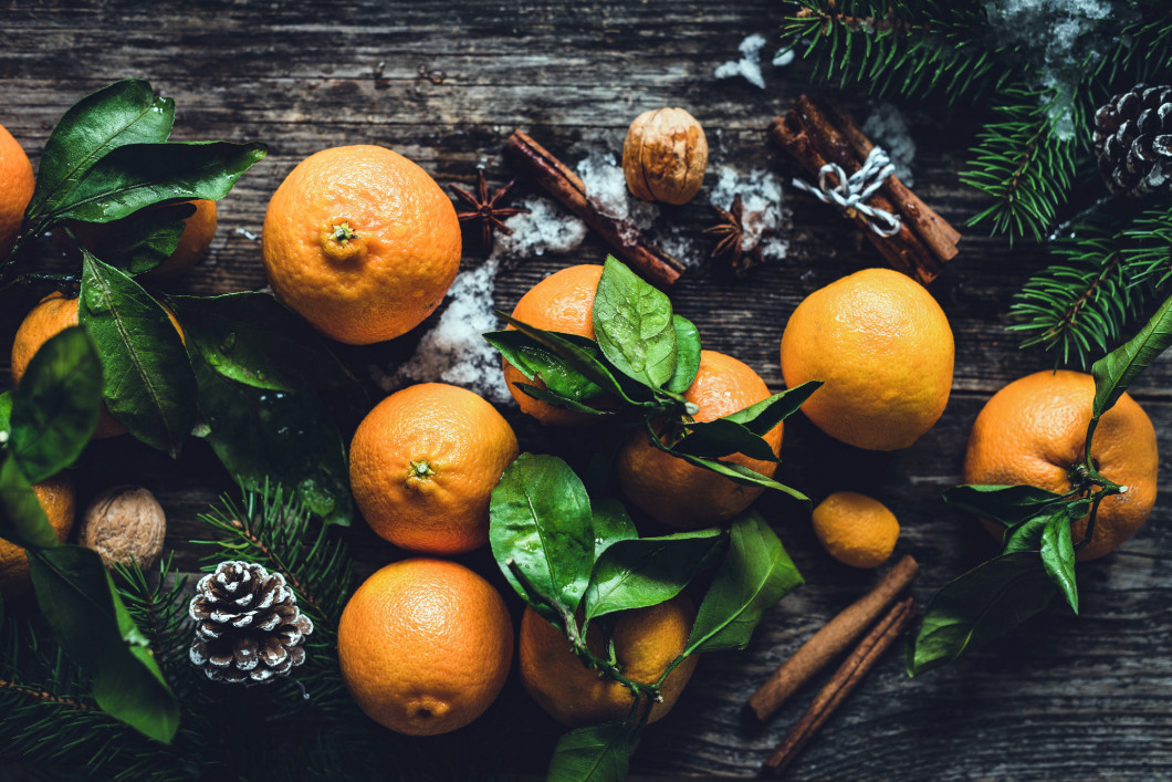 Tangerines, spices, pine cones and fir tree branches on wooden table.