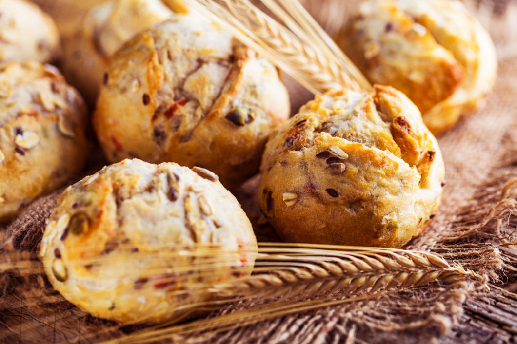 Different kinds of fresh bread on wooden table. Isolated assortm