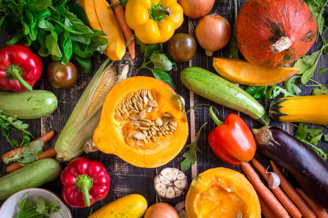 Fresh vegetables scaterred on a rustic dark textured table. Autu