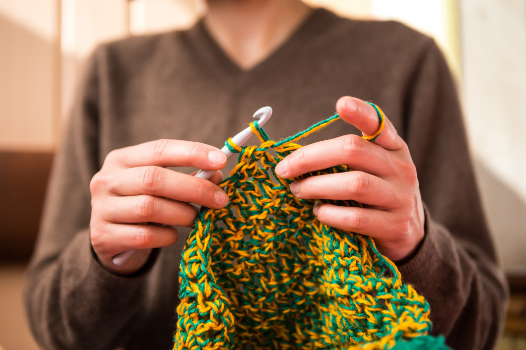 The woman is crocheting.