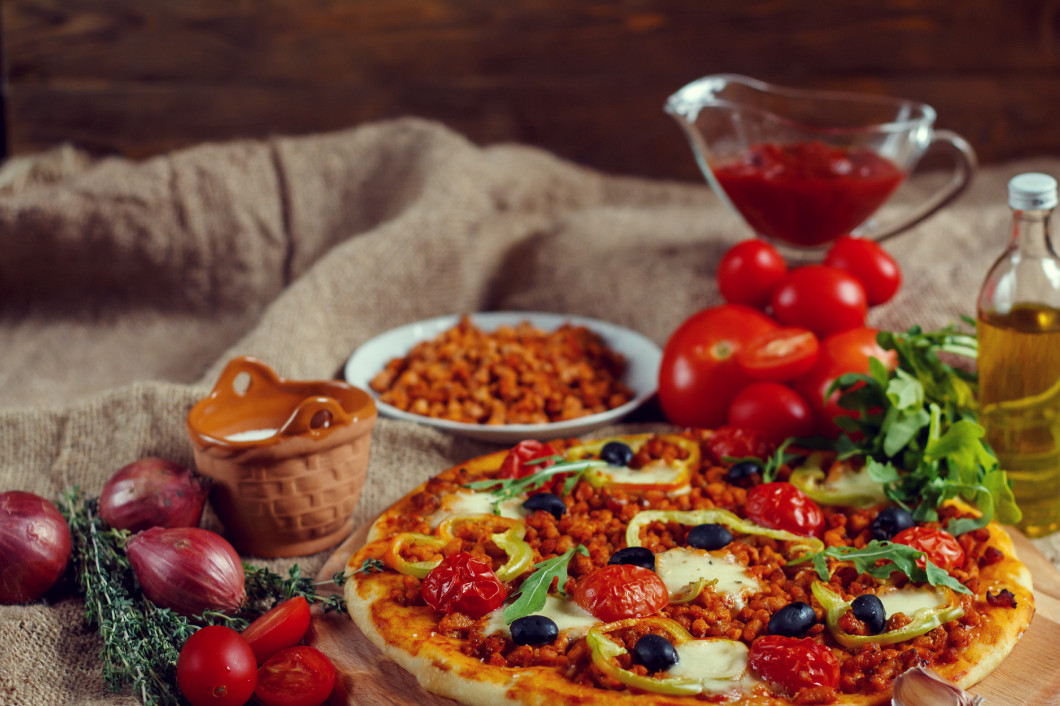 Pizza bolognese on a wooden board.