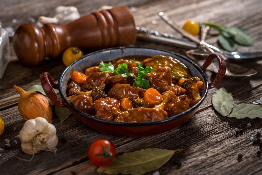 Meat stew with vegetable on rustic wooden background