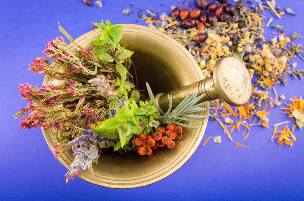 Dried herbs in a golden mortar