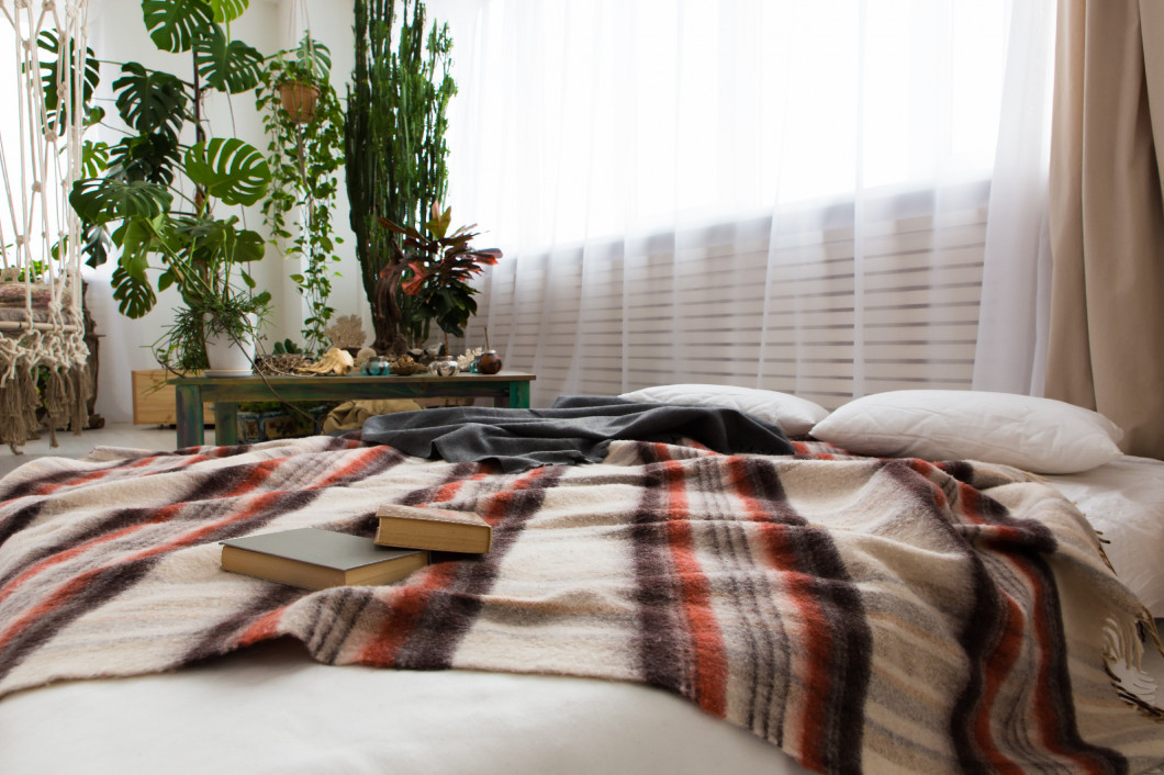 interior of a modern studio apartment with lots of plants and a bed on the floor