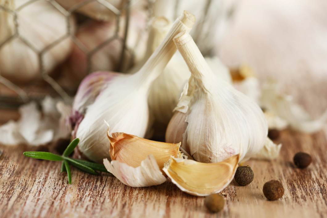 Raw garlic and spices on wooden table