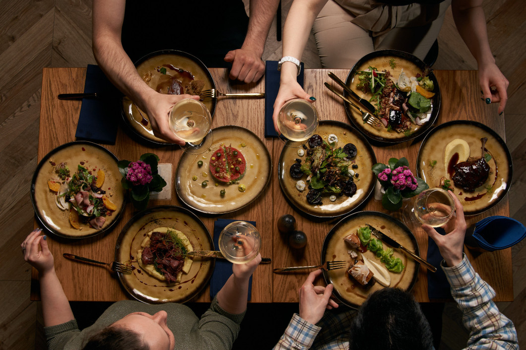 Group of people having dinner together while sitting at the table 