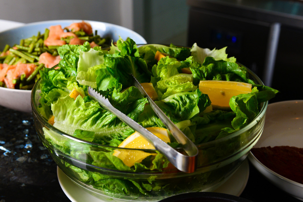 Salads in individual containers displayed on a buffet