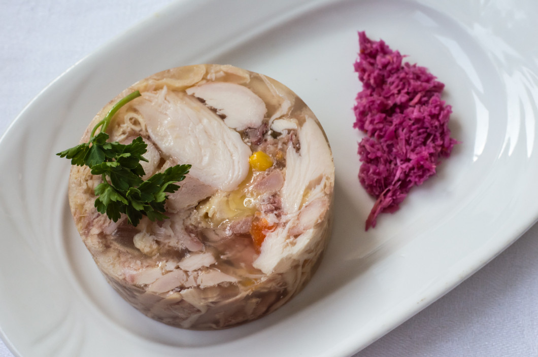 Aspic with meat and horseradish on a white table. Top view. Close-up