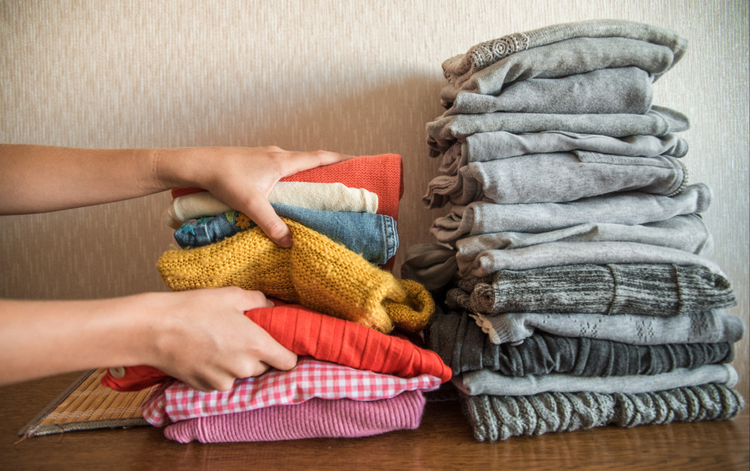 Red orange and yellow bright stack of clothes against the gray. The concept of choice and individuality