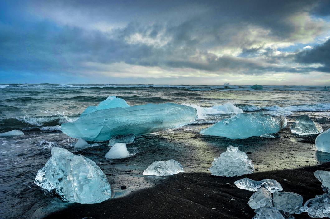 Icebergs floating in Jokulsarlon glacier lake at sunset in Icela