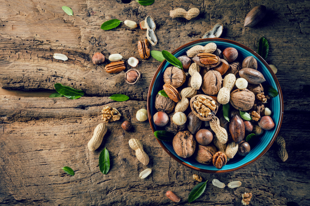 Walnut kernels and whole walnuts on rustic old oak table