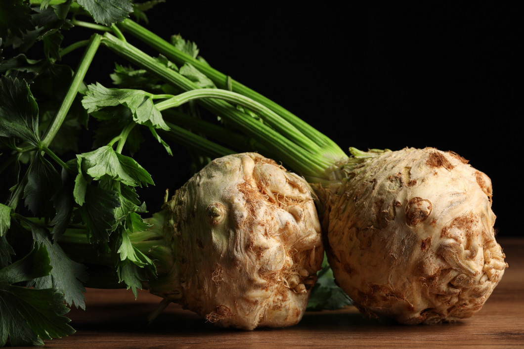 Fresh raw celery roots on wooden table, closeup