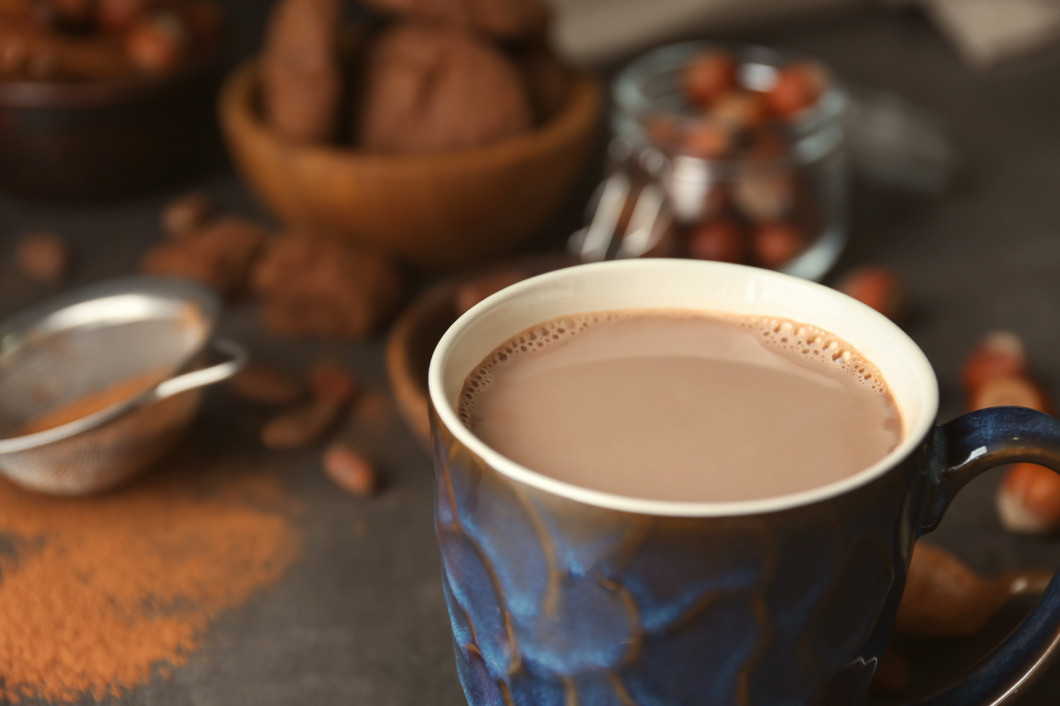 Cup with hot cocoa drink on table�