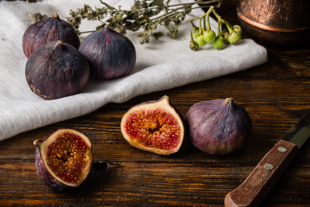 Ripe figs on cloth with sliced one and some objects