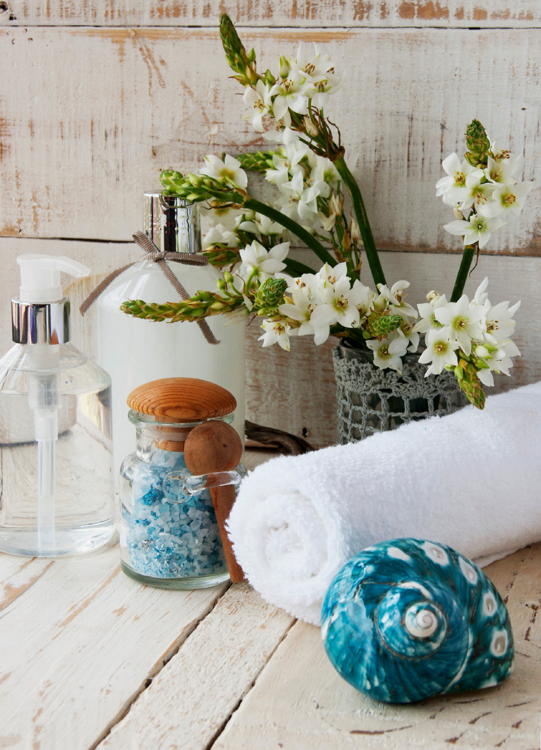 Spa set, towel, flowers on wooden white background