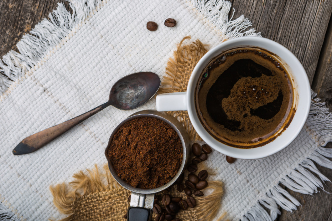 Ground coffee with coffee beans and cup of coffee