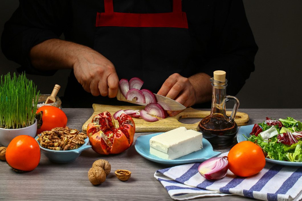 Cooking salad with persimmon by chef hands, steps process on kitchen on black background copy text recipe