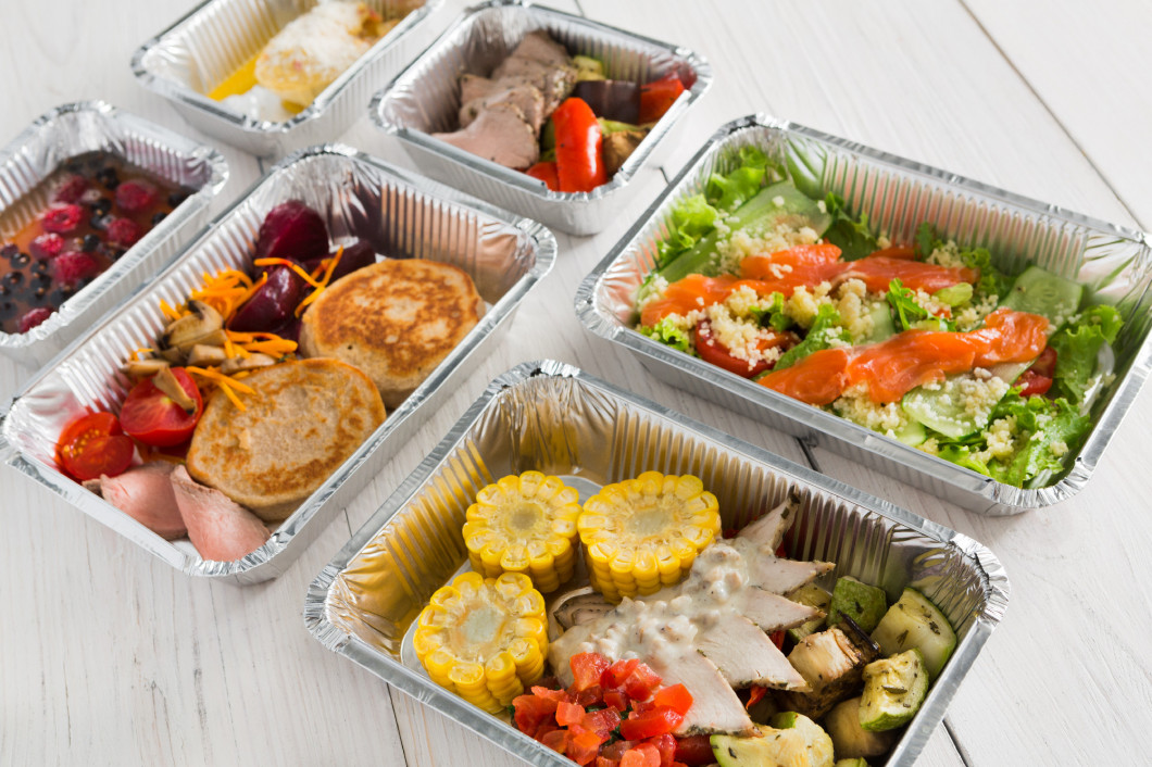 Healthy food take away in boxes, top view at wood