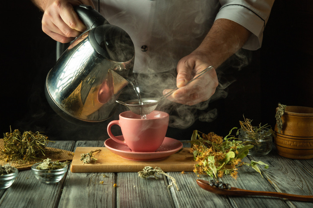 Steam rises as a skilled hand pours hot water over carefully sel