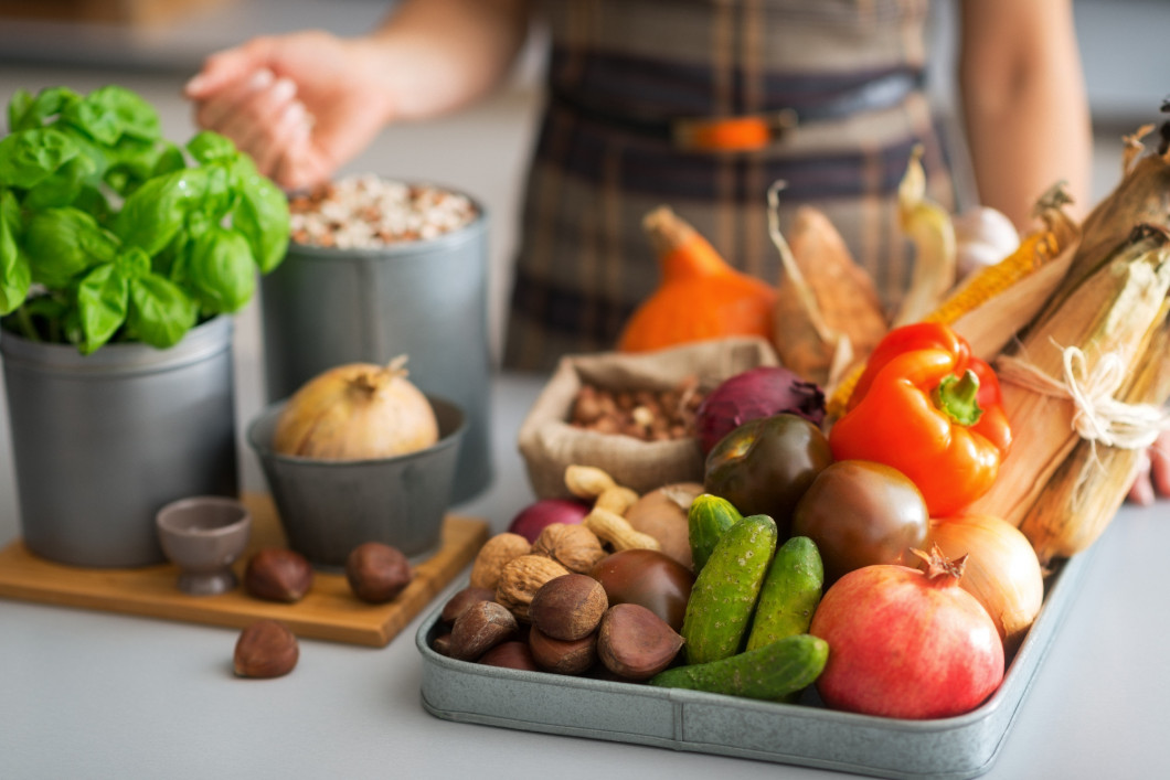 Closeup on young housewife with vegetables in kitchen