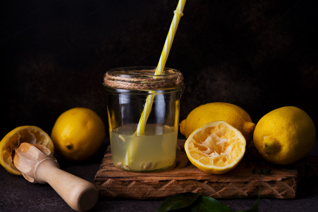 Fresh squeezed juice from lemon halves with a juicer in a glass 